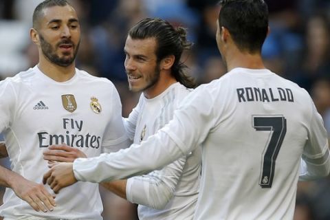 Real Madrid's Karim Benzema, left, celebrates with teammates Cristiano Ronaldo, right, and Gareth Bale after scoring their side's third goal against Getafe during the Spanish La Liga soccer match between Real Madrid and Getafe at the Santiago Bernabeu stadium in Madrid, Saturday, Dec. 5, 2015. Benzema scored twice and Ronaldo and Bale scored once each in Real Madrid's 4-1 victory. (AP Photo/Francisco Seco)