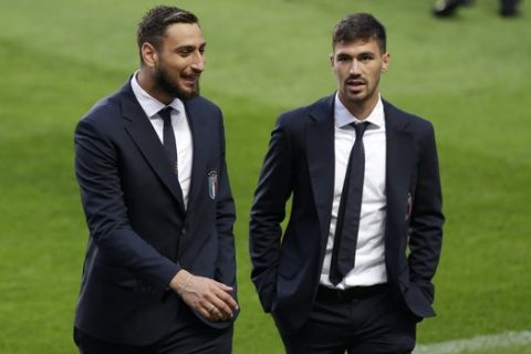 Italy goalkeeper Gianluigi Donnarumma, left, and teammate Alessio Romagnoli walk on the pitch during a visit to the Luz stadium in Lisbon, Sunday, Sept. 9, 2018. Italy will play Portugal Monday in a UEFA Nations League soccer match. (AP Photo/Armando Franca)