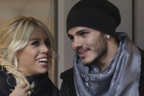 Inter Milan forward Mauro Icardi, of Argentina, is flanked by Argentine model Wanda Nara as they sit in the stands prior to a Serie A soccer match between Inter Milan and Chievo, at the San Siro stadium in Milan, Italy, Monday, Jan.13, 2014. (AP Photo/Luca Bruno)

