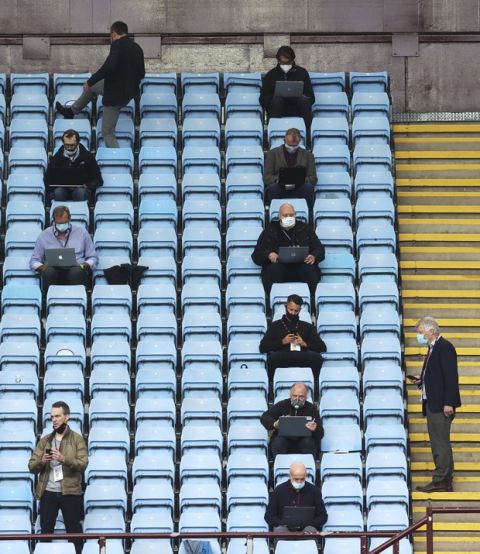 Journalists sit on the tribune prior to the start of the English Premier League soccer match between Aston Villa and Sheffield United at Villa Park in Birmingham, England, Wednesday, June 17, 2020. The English Premier League resumes Wednesday after its three-month suspension because of the coronavirus outbreak. (Carl Recine/Pool via AP)