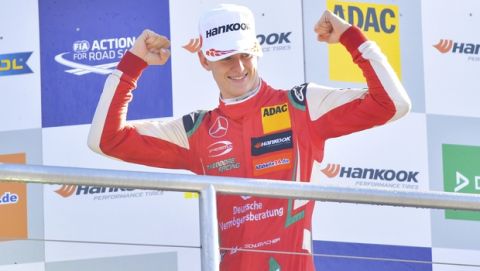 Mick Schumacher, son of former multiple Formula One champion Michael Schumacher, waves when celebrating becoming overall winner in FIA Formula 3 European Championships at the Hockenheim race track in Hockenheim, southern Germany, Sunday, Oct. 14, 2018. (Uwe Anspach/dpa via AP)