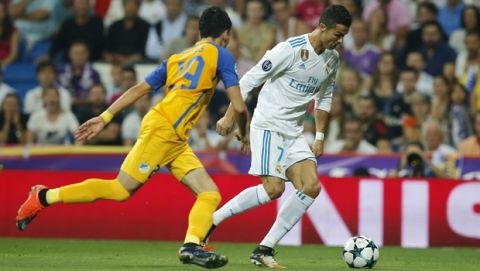Real Madrid's Cristiano Ronaldo, right, and APOEL Nicosia's Praksitelis Vouros battle for the ball during a Champions League group H soccer match between Real Madrid and Apoel Nicosia at the Santiago Bernabeu stadium in Madrid, Spain, Wednesday, Sept. 13, 2017. (AP Photo/Paul White)