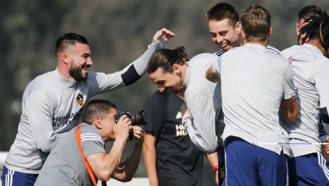 LA Galaxy's newest player Zlatan Ibrahimovic, third left, of Sweden, is greeted by teammates during an MLS soccer training session at the StubHub Center, Friday, March 30, 2018, in Carson, Calif. (AP Photo/Ringo H.W. Chiu)