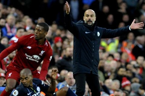 Manchester City manager Josep Guardiola appeals for a foul after Liverpool's Georginio Wijnaldum, standing, and Manchester City's Fernandinho, sitting, collided during the English Premier League soccer match between Liverpool and Manchester City at Anfield stadium in Liverpool, England, Sunday, Oct. 7, 2018. (AP Photo/Rui Vieira)