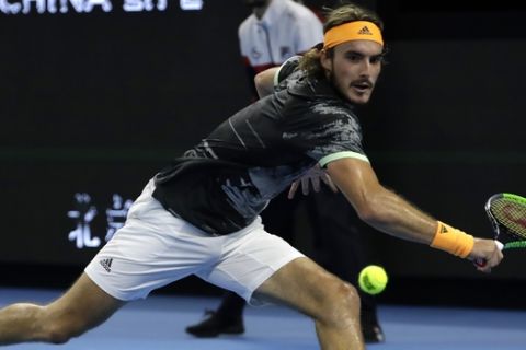 Stefanos Tsitsipas of Greece hits a return shot while competing against Alexander Zverev of Germany in their semifinal match in the China Open tennis tournament in Beijing, Saturday, Oct. 5, 2019. (AP Photo/Mark Schiefelbein)
