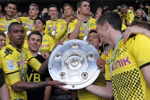 Dortmund's players celebrate with the trophy after the German first football division Bundesliga match between Borussia Dortmund and SC Freiburg in Dortmund, western Germany, on May 5, 2012.    AFP PHOTO / POOL / FEDERICO GAMBARINI

RESTRICTIONS / EMBARGO - DFB LIMITS THE USE OF IMAGES ON THE INTERNET TO 15 PICTURES (NO VIDEO-LIKE SEQUENCES) DURING THE MATCH AND PROHIBITS MOBILE (MMS) USE DURING AND FOR FURTHER TWO HOURS AFTER THE MATCH. FOR MORE INFORMATION CONTACT DFB.FEDERICO GAMBARINI/AFP/GettyImages