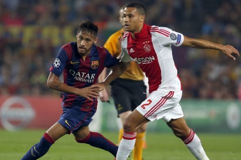 Barcelona's Neymar, left,  and Ajax's Ricardo van Rhijn challenges for the ball during the Champions League group F soccer match between F.C. Barcelona and Ajax at Camp Nou stadium in Barcelona, Spain, Tuesday, Oct. 21, 2014. (AP Photo/Emilio Morenatti)