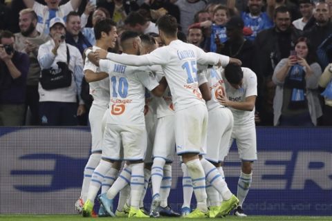 Marseille players celebrate after Marseille's Morgan Sanson scored his side's opening goal during the French League One soccer match between Marseille and Lille at the Velodrome stadium in Marseille, southern France, Saturday, Nov. 2, 2019. (AP Photo/Daniel Cole)