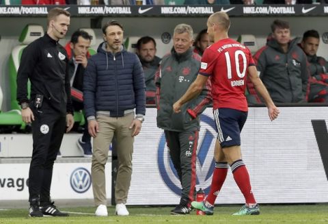 Bayern coach Niko Kovac, 2nd left, looks at Bayern's Arjen Robben, right, leaving the pitch after Robben received a red card during the German Bundesliga soccer match between VfL Wolfsburg and FC Bayern Munich in Wolfsburg, Germany, Saturday, Oct. 20, 2018. (AP Photo/Michael Sohn)