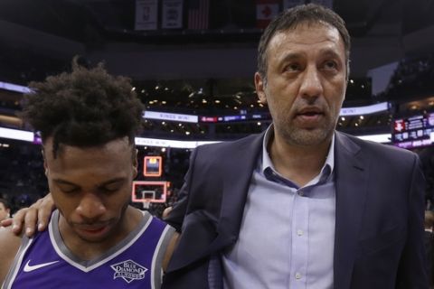 Sacramento Kings guard Buddy Hield, left, and Vlade Divac, the Kings vice president of basketball operations and general manager walk off the court together after the Kings defeated the Houston Rockets 96-83 in an NBA basketball game, Wednesday, April 11, 2018, in Sacramento, Calif. (AP Photo/Rich Pedroncelli)