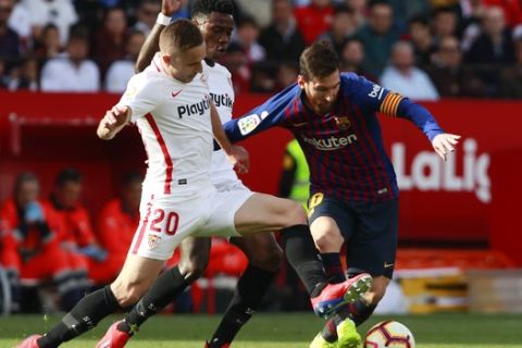 Barcelona forward Lionel Messi, right, and Sevilla's Rog fight for the ball during La Liga soccer match between Sevilla and Barcelona at the Ramon Sanchez Pizjuan stadium in Seville, Spain. Saturday, February 23, 2019. (AP Photo/Miguel Morenatti)