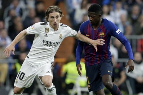 Real midfielder Luka Modric, left, and Barcelona forward Ousmane Dembele challenge for the ball during the Spanish La Liga soccer match between Real Madrid and FC Barcelona at the Bernabeu stadium in Madrid, Saturday, March 2, 2019. (AP Photo/Andrea Comas)