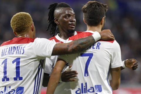 Lyon's Martin Terrier, right, celebrates with teammates Memphis Depay, left, and Bertrand Traore, center, after he scored a goal against Strasbourg during their French League One soccer match in Decines, near Lyon, central France, Friday, Aug. 24, 2018. (AP Photo/Laurent Cipriani)