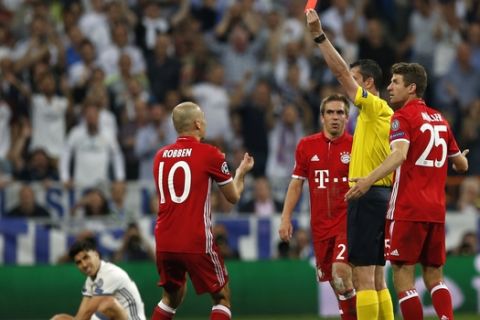 Bayern's Arjen Robben, center, gestures as referee Viktor Kassai of Hungary shows a red card to Bayern's Arturo Vidal during the Champions League quarterfinal second leg soccer match between Real Madrid and Bayern Munich at Santiago Bernabeu stadium in Madrid, Spain, Tuesday April 18, 2017. (AP Photo/Francisco Seco)