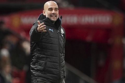 Manchester City's manager Pep Guardiola gestures his player from the sidelines during the English League Cup semifinal first leg soccer match between Manchester United and Manchester City and at Old Trafford, Manchester, England, Tuesday, Jan. 7, 2020. (AP Photo/Jon Super)