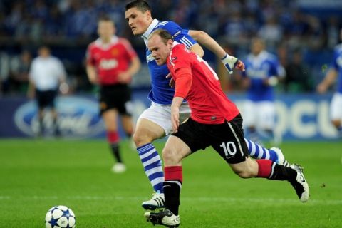 GELSENKIRCHEN, GERMANY - APRIL 26:  Kyriakos Papadopoulos of Schalke competes with Wayne Rooney of Manchester United during the UEFA Champions League Semi Final first leg match between FC Schalke 04 and Manchester United at Veltins Arena on April 26, 2011 in Gelsenkirchen, Germany. (Photo by Jamie McDonald/Getty Images)