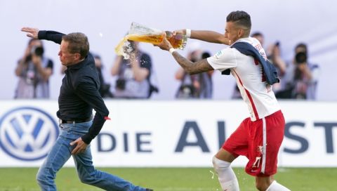 Leipzig's Davie Selke, right, gives a beer shower to RB Leipzig coach Ralf Rangnick, left, after winning the German second division Bundesliga soccer match between RB Leipzig and Karlsruhe SC at the Red Bull Arena soccer stadium in Leipzig, Germany, Sunday, May 8, 2016. Leipzig joined German second-division champion Freiburg in the Bundesliga next season, clinching promotion with a 2-0 win at home over Karlsruher SC. (AP Photo/Jens Meyer)