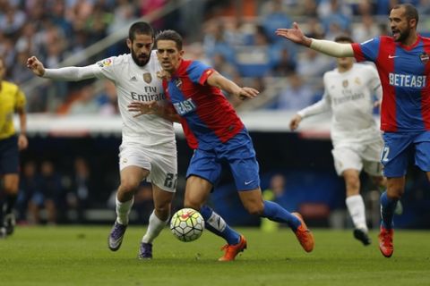 Real Madrid's Isco, left, duels for the ball with Levante's Zou Feddal during a Spanish La Liga soccer match between Real Madrid and Levante at the Santiago Bernabeu stadium in Madrid, Spain, Saturday, Oct. 17, 2015. (AP Photo/Daniel Ochoa de Olza)