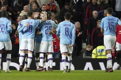 Manchester City's Kevin De Bruyne celebrates with teammates after Manchester United's Andreas Pereira was adjudged to have scored an own goal and City's third goal of the game during the English League Cup semifinal first leg soccer match between Manchester United and Manchester City and at Old Trafford, Manchester, England, Tuesday, Jan. 7, 2020. (AP Photo/Jon Super)