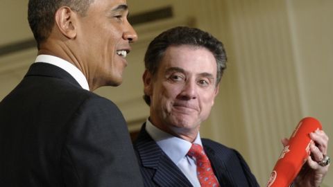 President Barack Obama is presented with a Louisville Slugger baseball bat from Louisville men's basketball coach Rick Pitino, right, during an event to honor the 2013 NCAA Mens Basketball Champions, the Louisville Cardinals, in the East Room of the White House in Washington, Tuesday, July 23, 2013. (AP Photo/Susan Walsh)