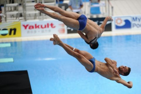 Greece's Alexandros Manos and Stefanos Paparounas compete in the preliminary round of the men's 3-metre synchronised springboard diving event in the FINA World Championships at the outdoor diving pool of the Oriental Sports Centre in Shanghai on July 19, 2011. AFP PHOTO / PETER PARKS (Photo credit should read PETER PARKS/AFP/Getty Images)