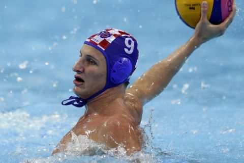 Sandro Sukno of Croatia holds the ball in a preliminary water polo match agains Greece at the 2012 Summer Olympics, Sunday, July 29, 2012, in London. (AP Photo/Julio Cortez)