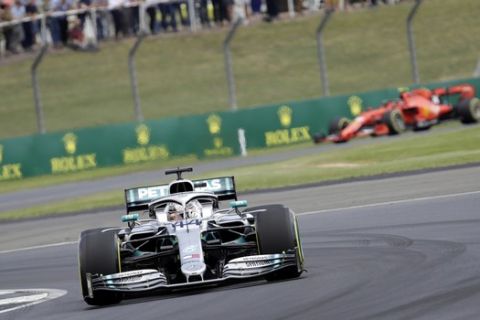 Mercedes driver Lewis Hamilton of Britain takes a curve followed by Ferrari driver Charles Leclerq of Monaco, right, during the second free practice at the Silverstone racetrack, in Silverstone, England, Friday, July 12, 2019. The British Formula One Grand Prix will be held on Sunday. (AP Photo/Luca Bruno)
