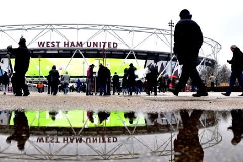 West Ham United fans outside the ground before their English Premier League soccer match against Bournemouth at London Stadium, in London, Saturday Jan. 20, 2018. Parts of England have been deluged by heavy rain Saturday, which is predicted to continue for the coming days. (Dominic Lipinski/PA via AP)