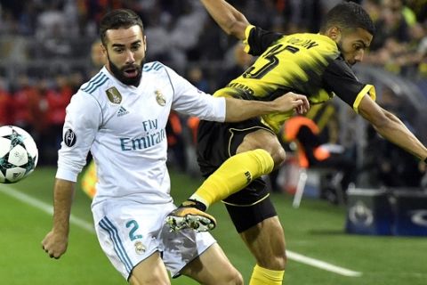 Real Madrid's Daniel Carvajal, left, and Dortmund's Jeremy Toljan, right, challenge for the ball during the Champions League group H soccer match between Borussia Dortmund and Real Madrid CF in Dortmund, Germany, Tuesday, Sept. 26, 2017. (AP Photo/Martin Meissner)