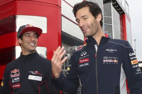 Red Bull driver Mark Webber of Australia, right, gestures with Toro Rosso driver Daniel Ricciardo of Australia prior to the start of the first free practice at the Spa-Francorchamps circuit, Belgium, Friday, Aug. 23, 2013. Daniel Ricciardo is widely expected to step up from Toro Rosso and replace Webber. The Belgium Formula One Grand Prix will be held on Sunday. (AP Photo/Luca Bruno)