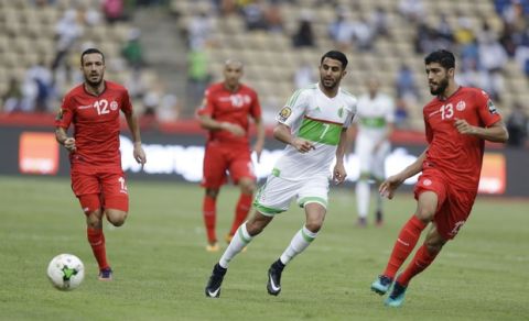 Algeria's, Riyad Mahrez, center, is challenged by Tunisia's, Ali Maaloul, left, and Ferjani Sassi, right, during the African Cup of Nations Group B soccer match between Algeria and Tunisia at, Stade de Franceville Stadium, Gabon, Thursday, Jan. 19, 2017. (AP Photo/Sunday Alamba)