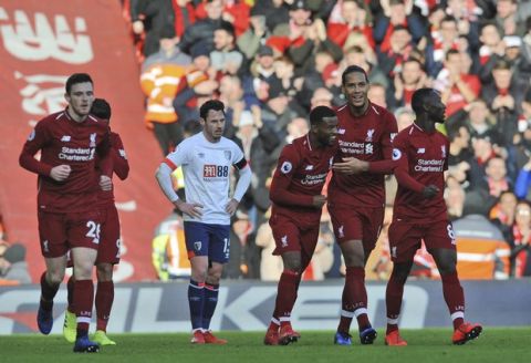 Liverpool's Georginio Wijnaldum, center, celebrates with Liverpool's Virgil van Dijk, center right, after scoring his side's second goal during the English Premier League soccer match between Liverpool and AFC Bournemouth at Anfield stadium in Liverpool, England, Saturday, Feb. 9, 2019. (AP Photo/Rui Vieira)