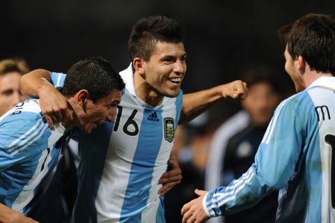 Argentine forward Sergio Aguero (C) celebrates with teammates midfielder Angel di Maria (L) and forward Lionel Messi, after scoring against Costa Rica, during a 2011 Copa America Group A first round football match, at the Mario Kempes stadium in Cordoba, 770 Km northwest of Buenos Aires, on July 11, 2011.    AFP PHOTO / RODRIGO BUENDIA (Photo credit should read RODRIGO BUENDIA/AFP/Getty Images)