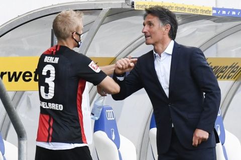 Hertha's German head coach Bruno Labbadia, right, and Norwegian midfielder Per Ciljan Skjelbred congratulate after Hertha won 3-0 during the Bundesliga soccer match between TSG 1899 Hoffenheim and Hertha BSC Berlin in Sinsheim, Germany, Saturday, May 16, 2020. The German Bundesliga becomes the world's first major soccer league to resume after a two-month suspension because of the coronavirus pandemic. (Thomas Kienzle/AFP pool via AP)
