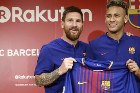 FC Barcelona's Lionel Messi, left, and Neymar pose with their new jersey during a press conference in Tokyo Thursday, July 13, 2017.  They are in the city to introduce Japanese online retailer Rakuten as the main global sponsor of the soccer club. (AP Photo/Eugene Hoshiko)