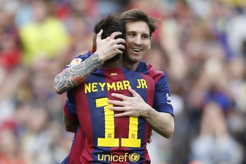 FC Barcelona's Lionel Messi, from Argentina, background, embraces his teammate Neymar, from Brazil, left, after scoring against Deportivo Coruna during a Spanish La Liga soccer match at the Camp Nou stadium in Barcelona, Spain, Saturday, May 23, 2015. (AP Photo/Manu Fernandez)