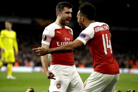 Arsenal's Sokratis Papastathopoulos, left, celebrates with Arsenal's Pierre-Emerick Aubameyang after scoring his side's third goal during the Europa League round of 32 second leg soccer match between Arsenal and Bate at the Emirates stadium in London, Thursday, Feb. 21, 2019. (AP Photo/Matt Dunham)