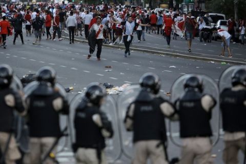 Argentina River Plate fans clash with riot police outside the Antonio Vespucio Liberti stadium prior the final soccer match of the Copa Libertadores between River Plate and Boca Juniors, in Buenos Aires, Argentina, Saturday, Nov. 24, 2018. The match has been rescheduled after the bus carrying the Boca Juniors players was attacked by River Plate fans, injuring several players. The match will be played on Sunday. (AP Photo/Sebastian Pani)