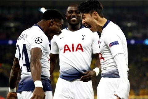 Tottenham midfielder Son Heung-min celebrates with defender Serge Aurier, left, after scoring the opening goal during the Champions League round of 16, first leg, soccer match between Tottenham Hotspur and Borussia Dortmund at Wembley stadium in London, Wednesday, Feb. 13, 2019. (AP Photo/Alastair Grant)