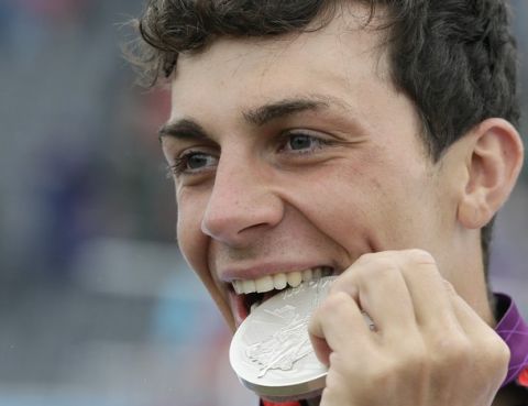 Sideris Tasiadis of Germany bites his silver medal after finishing second in the final of the C-1 men's canoe slalom at Lee Valley Whitewater Center, at the 2012 Summer Olympics, Tuesday, July 31, 2012, in Waltham Cross near London. (AP Photo/Kirsty Wigglesworth)