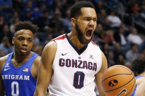 Gonzaga guard Silas Melson (0) reacts after dunking the ball while BYU guard Jahshire Hardnett (0) looks on in the first half of an NCAA college basketball game Saturday, Feb. 24, 2018, in Provo, Utah. (AP Photo/Rick Bowmer)