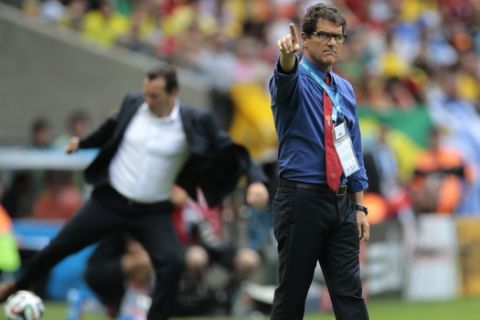 Russia's head coach Fabio Capello gestures as Belgium's head coach Marc Wilmots, left, kicks a ball in the background, during the group H World Cup soccer match between Belgium and Russia at the Maracana stadium in Rio de Janeiro, Brazil, Sunday, June 22, 2014. (AP Photo/Ivan Sekretarev)