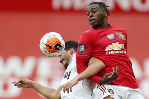 Manchester United's Aaron Wan-Bissaka, right, vie for the ball with West Ham's Pablo Fornals during the English Premier League soccer match between Manchester United and West Ham at the Old Trafford stadium in Manchester, England, Wednesday, July 22, 2020. (Clive Brunskill/Pool via AP)