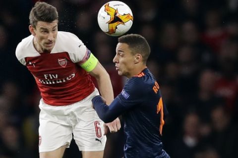 Arsenal's Laurent Koscielny, left, challenges for the ball with Valencia's Rodrigo during the Europa League semifinal first leg soccer match between Arsenal and Valencia at the Emirates stadium in London, Thursday, May 2, 2019. (AP Photo/Kirsty Wigglesworth)