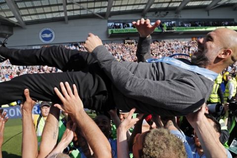 Manchester City coach Pep Guardiola is lifted in the air by the players after the English Premier League soccer match between Brighton and Manchester City at the AMEX Stadium in Brighton, England, Sunday, May 12, 2019. Manchester City defeated Brighton 4-1 to win the championship. (AP Photo/Frank Augstein)