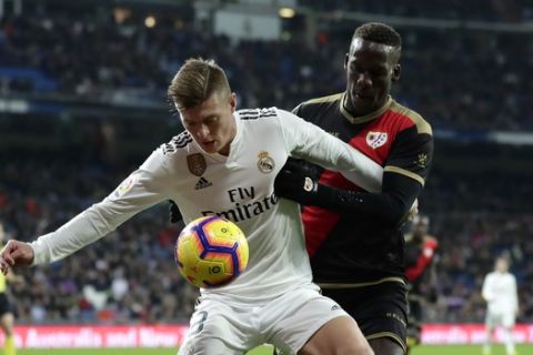Real Madrid's Toni Kroos, left, duels for the ball with Rayo Vallecano's Luis Advíncula during the Spanish La Liga soccer match between Real Madrid and Rayo Vallecano at the Bernabeu stadium in Madrid, Spain, Saturday, Dec. 15, 2018. (AP Photo/Manu Fernandez)