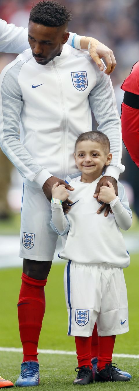 Bradley Lowery,front, is holding hands with England's Jermain Defoe prior to the World Cup Group F qualifying soccer match between England and Lithuania at the Wembley Stadium in London, Great Britain, Sunday, March 26, 2017. Bradley Lowery is battling a rare form of cancer and is set to lead England out onto the pitch at Wembley on March 26. (AP Photo/Kirsty Wigglesworth)