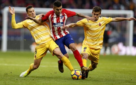 Atletico Madrid's Angel Correa, centre, tussles for the ball with Girona's Alex Granell, left, and Pere Pons during a Spanish La Liga soccer match between Atletico Madrid and Girona at the Wanda Metropolitano stadium in Madrid, Saturday, Jan. 20, 2018. The match ended in a 1-1 draw. (AP Photo/Francisco Seco)
