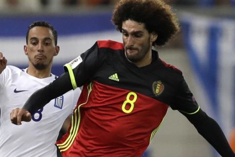 Belgium's Marouane Fellaini, right, goes for the ball with Greece's Zeca during the World Cup Group H qualifying soccer match between Greece and Belgium at Georgios Karaiskakis Stadium in Piraeus port, near Athens, Sunday, Sept. 3, 2017. (AP Photo/Thanassis Stavrakis)