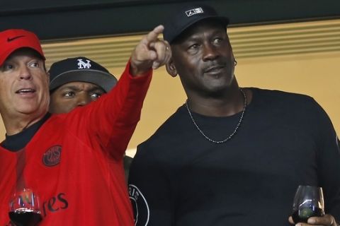 American former professional basketball player Michael Jordan, right, watches the French League One soccer match between Paris-Saint-Germain and Reims at the Parc des Princes stadium in Paris, France, Wednesday, Sept. 26, 2018. (AP Photo/Michel Euler)